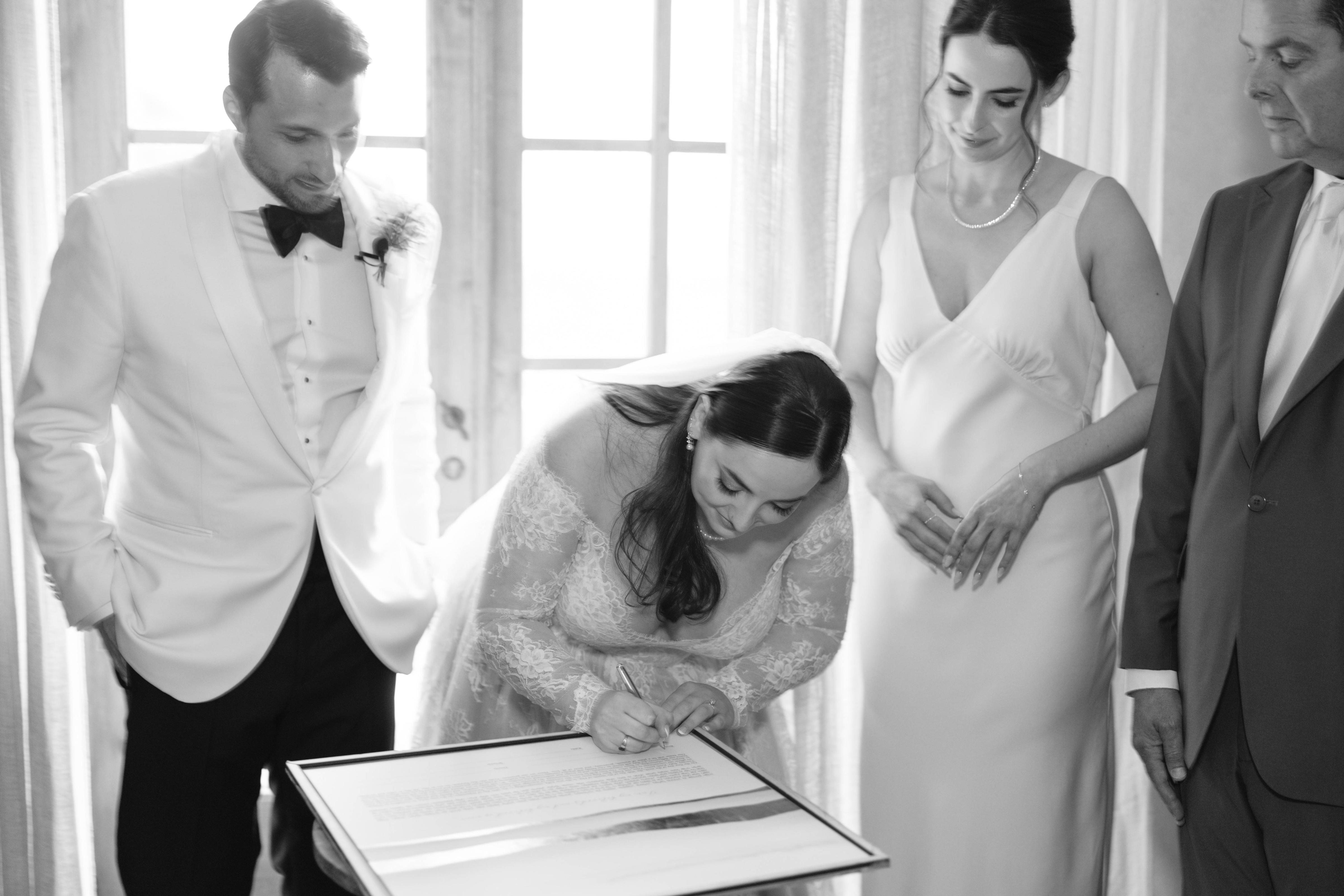 Just before the ceremony, the bride and groom gather with their Rabbi, immediate family, and witnesses in a private space to sign the Ketubah—which emphasizes building a home filled with love, respect, and Jewish values.