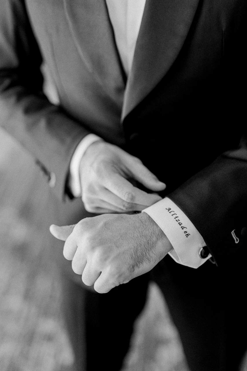 Grooms details of their last name printed on the cuff of his white shite.