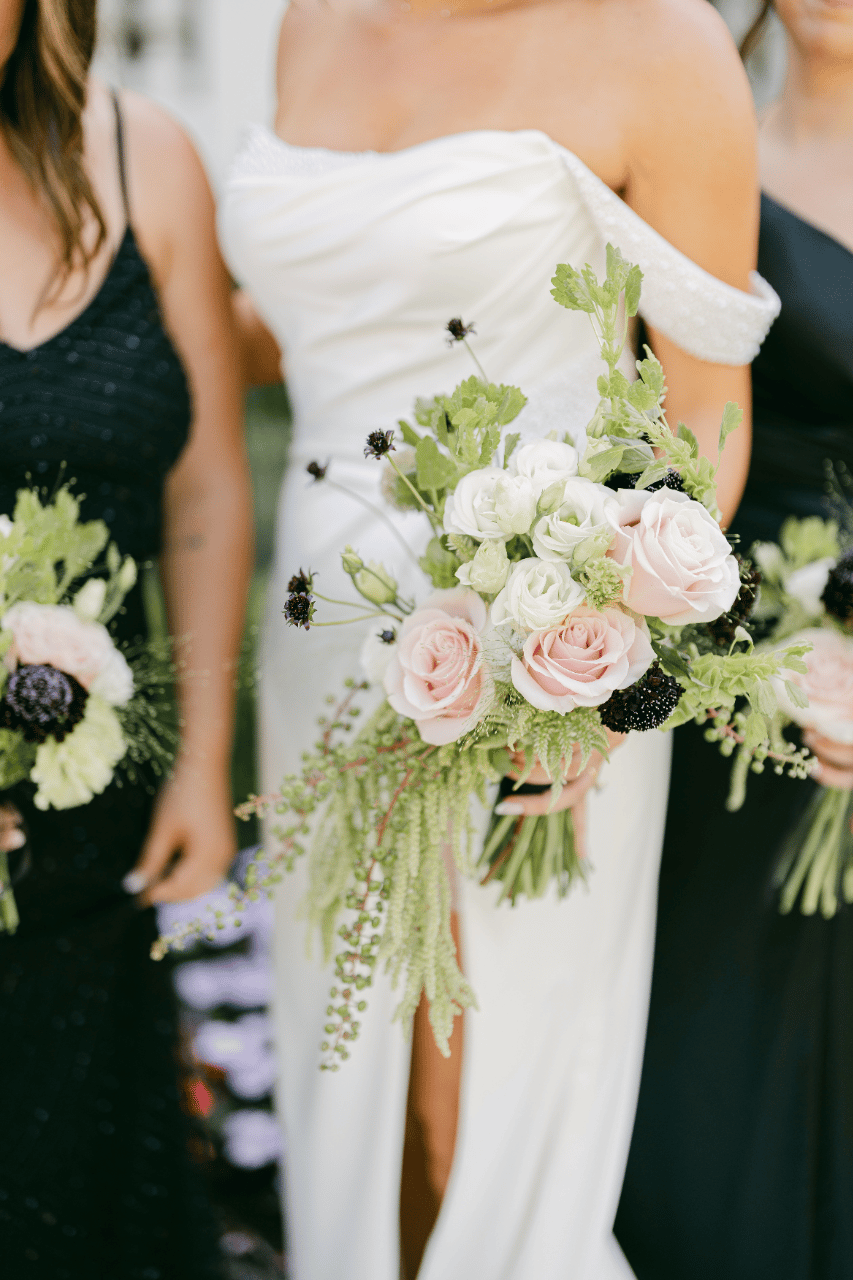 A small asymmetrical bridal Bouquet , Bells of Ireland, roses Pokeweed and amaranthus.