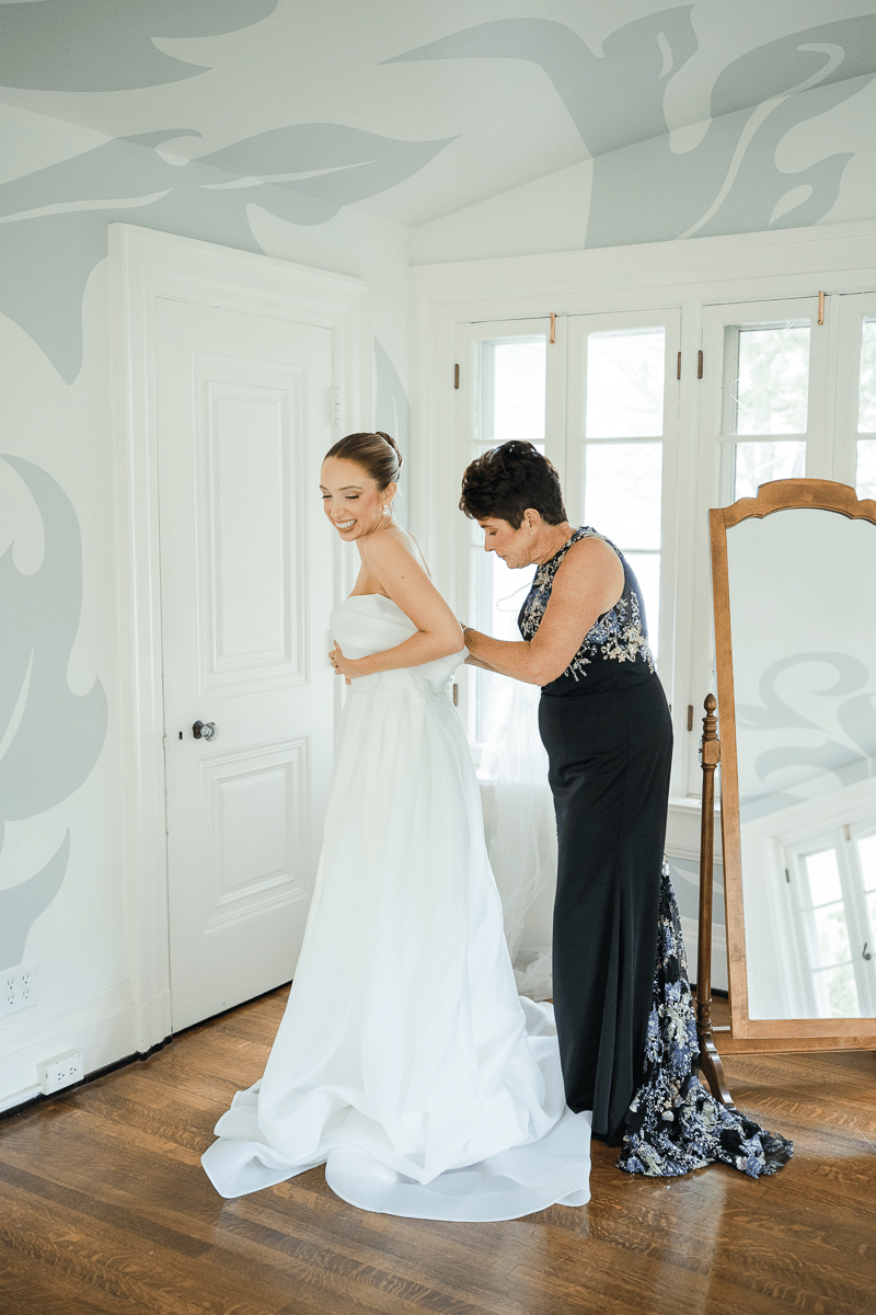 Ariel's mom assisting her put on her dress