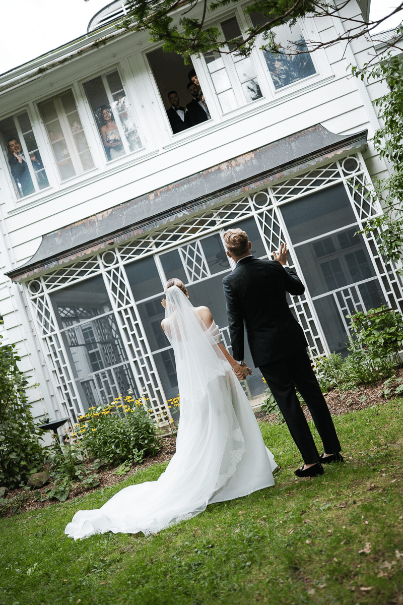 Wedding party looks over bride and groom as their have their first look