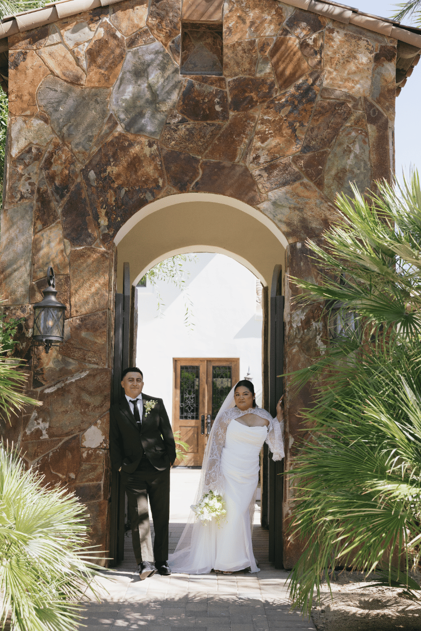 A soft, candid moment beneath the estate’s stone archway.