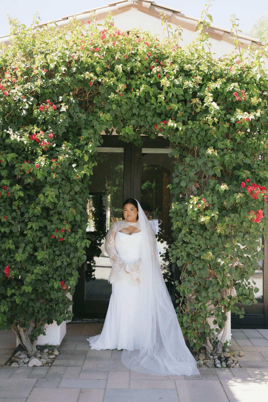 The bride framed by lush greenery, blending elegance with the natural setting.