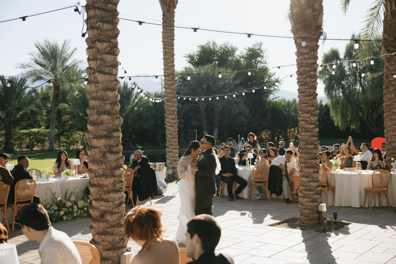 Guests gathered beneath palm-lined shade.